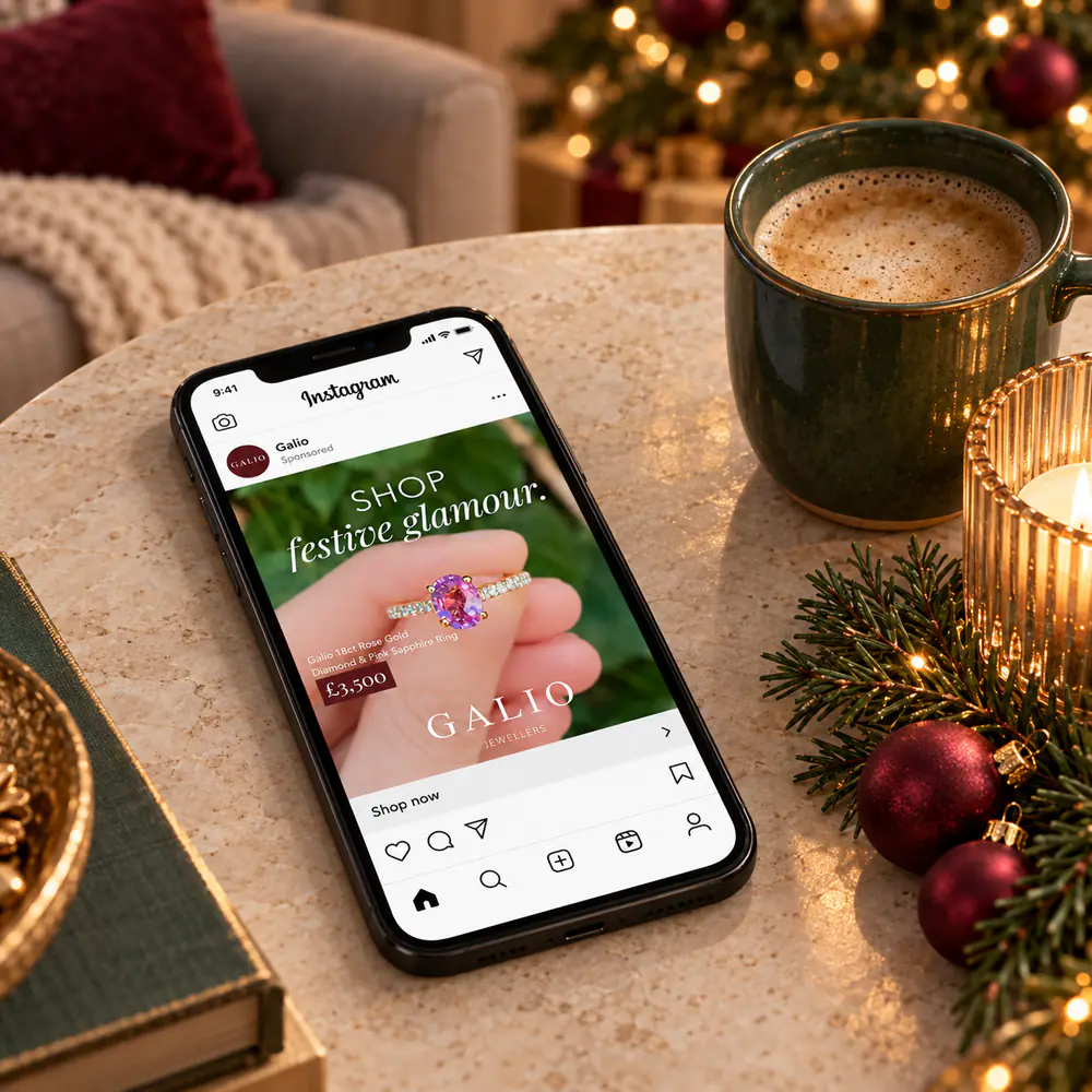 Galio Jewellers Instagram ad for a pink sapphire ring on a phone on a festive coffee table