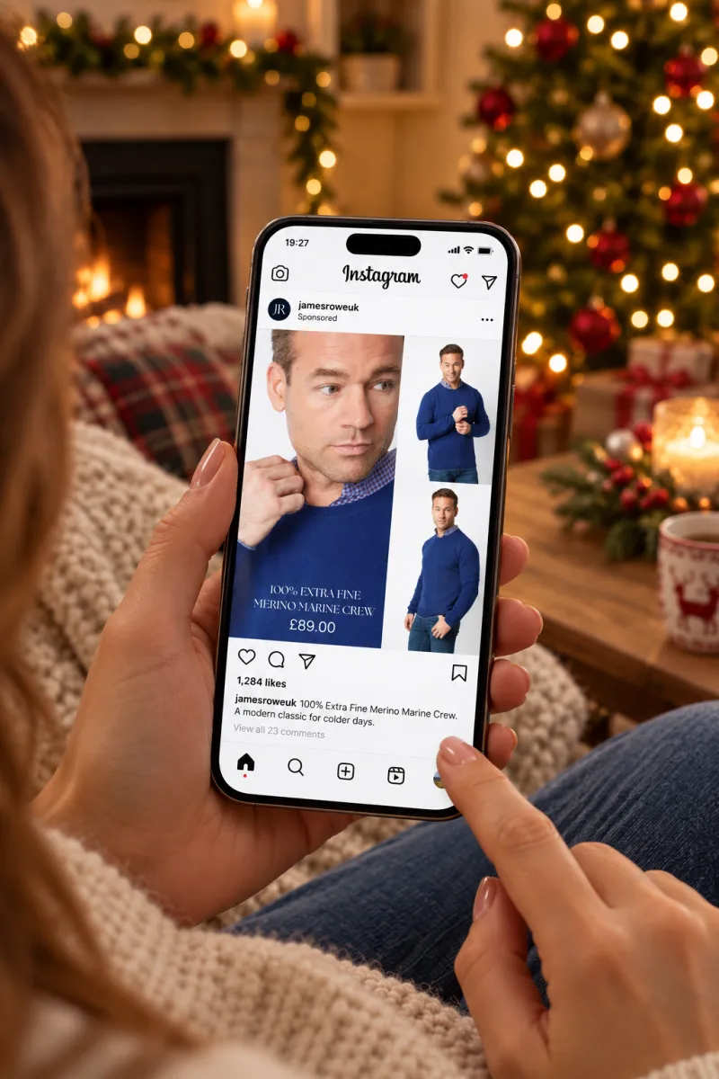 Merino knitwear ad viewed on a phone beside a Christmas tree